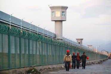 Workers walk by the perimeter fence of what is officially known as a vocational skills education center in Xinjiang Uighur Autonomous Region, China on September 4, 2018. (AP)