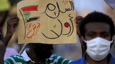 A demonstrator holds up a sign reading in Arabic peace first, Nertiti sit-in along with a drawn Sudanese flag, during a protest outside the Sudanese Professionals Association in the Garden City district of Sudan's capital Khartoum on July 4, 2020, in solidarity with the people of the Nertiti region of Central Darfur province in the country's southwest. Hundreds of Sudanese had held a protest the previous day in the Central Darfur state calling on the government to secure their properties following recent incidents of killings and looting. A week prior, unidentified armed men killed three farmers near the town of Nertiti in Central Darfur, triggering the ire of residents who long complained of lack of security in the area.