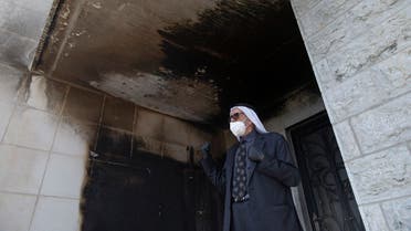 A Palestinian man inspects burned walls of a mosque at el-Bireh, near the West Bank city of Ramallah, Monday, July 27, 2020. (AP)