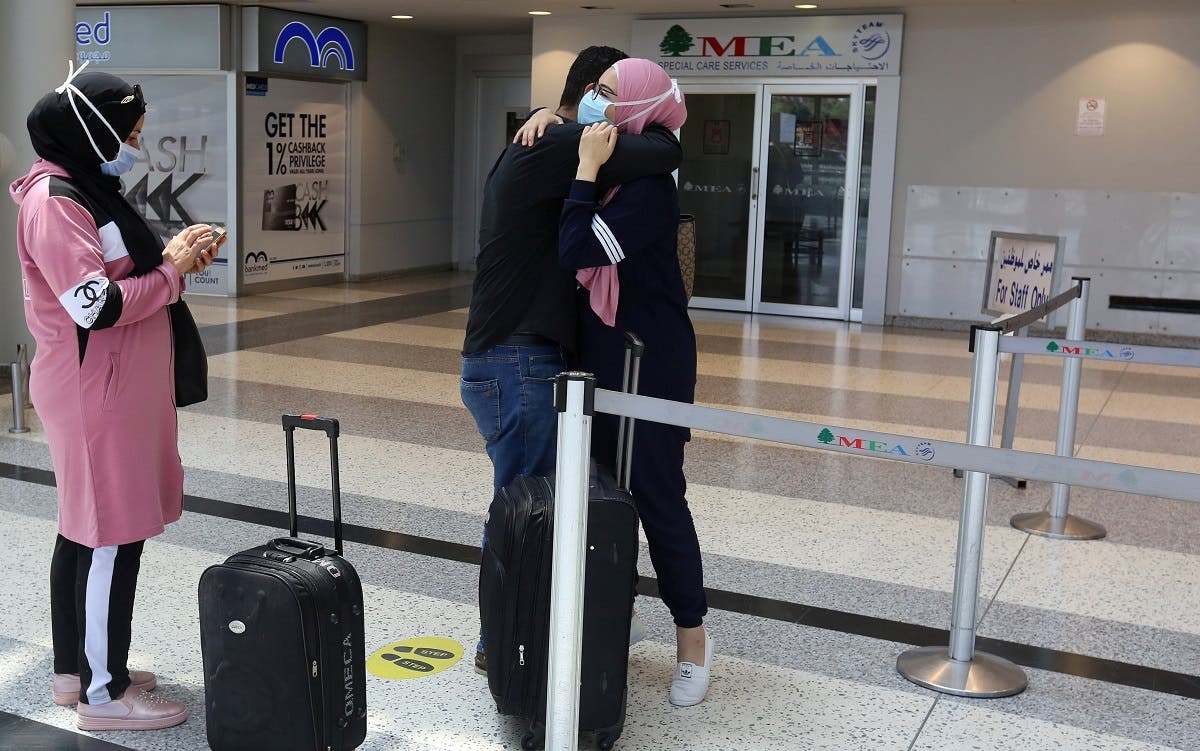 A woman wearing a face mask embraces a man before she heads to board a plane at Beirut International airport, Lebanon July 17, 2020. (Reuters)
