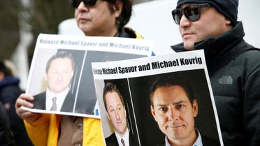 FILE PHOTO: People hold signs calling for China to release Canadian detainees Michael Spavor and Michael Kovrig during an extradition hearing for Huawei Technologies Chief Financial Officer Meng Wanzhou at the B.C. Supreme Court in Vancouver, British Columbia, Canada, March 6, 2019. REUTERS/Lindsey Wasson/File Photo