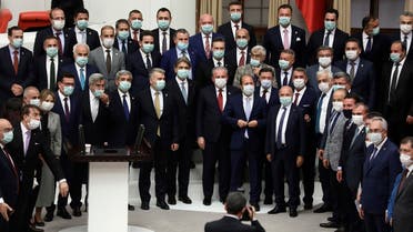 Turkey's ruling Justice and Development (AK) Party Tekirdag Deputy Mustafa Sentop (cnetere red tie) poses with deputies, all wearig a protective face mask, at the General Assembly after being re-elected as the Speaker of the Turkish Parliament in Ankara, Turkey on July 7, 2020. (AFP)