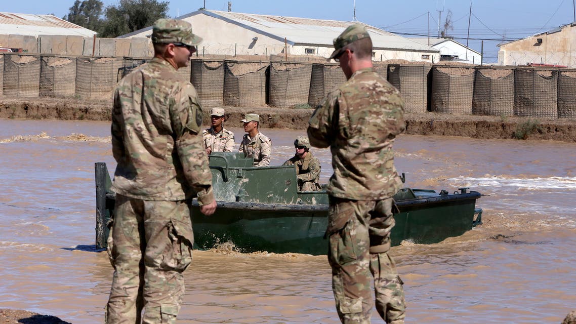 US army forces supervise during a training session at the Taji camp, north of Baghdad, with Iraqi soldiers, aimed at preparing them to install floating bridges, ahead of installing replacement ones in Mosul, on March 6, 2017. Members of the Iraqi army's Bridging Battalion who have completed the training will be deployed in the area of Mosul, where government-led forces are fighting to retake the Islamic State jihadist group's last urban stronghold in the country. Iraqi forces have deployed floating bridges on a number of occasions as they waged war against the jihadists in the Land of the Two Rivers.