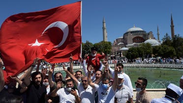 Turkish people, one holding a flag, chant slogans outside the Hagia Sophia on July 24, 2020. (AP)