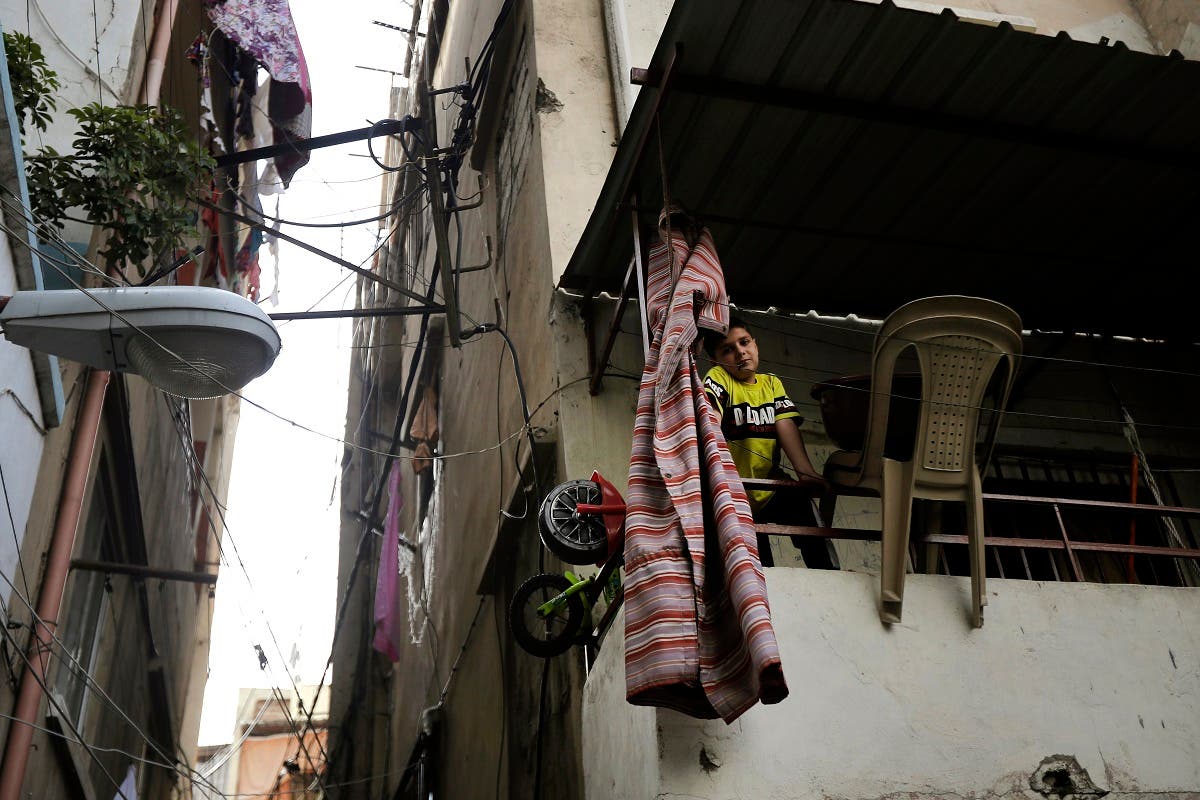 A boy looks out from a balconey along an alley in the Bab al-Tabbaneh neighbourhood of Lebanon's northern city of Tripoli on June 3, 2020. (AFP)