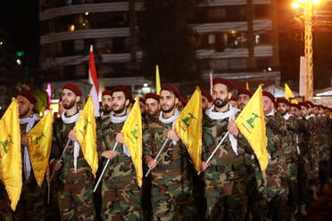 Fighters with the Lebanese Shia Hezbollah group, carry flags as they parade in a southern suburb of the capital Beirut, on May 31, 2019. (AFP)