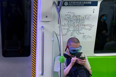 A commuter wearing a goggle and protective face mask to help curb the spread of the new coronavirus sits on the seat of a subway train in Beijing on June 16, 2020. (AP)