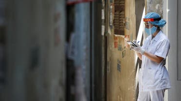 A healthcare worker is seen at a lane near the house of a coronavirus disease (COVID-19) patient while investigating infection links in Hanoi. (Reuters)