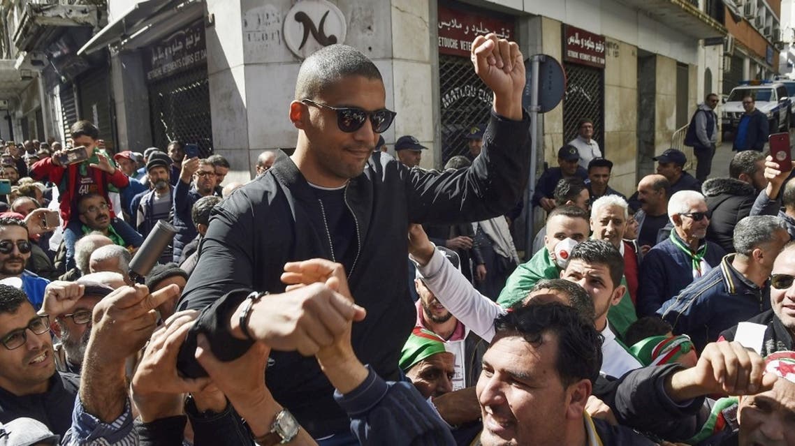 A picture taken on March 6, 2020 shows Algerian protesters carrying journalist Khaled Drareni on their shoulders. (AFP)