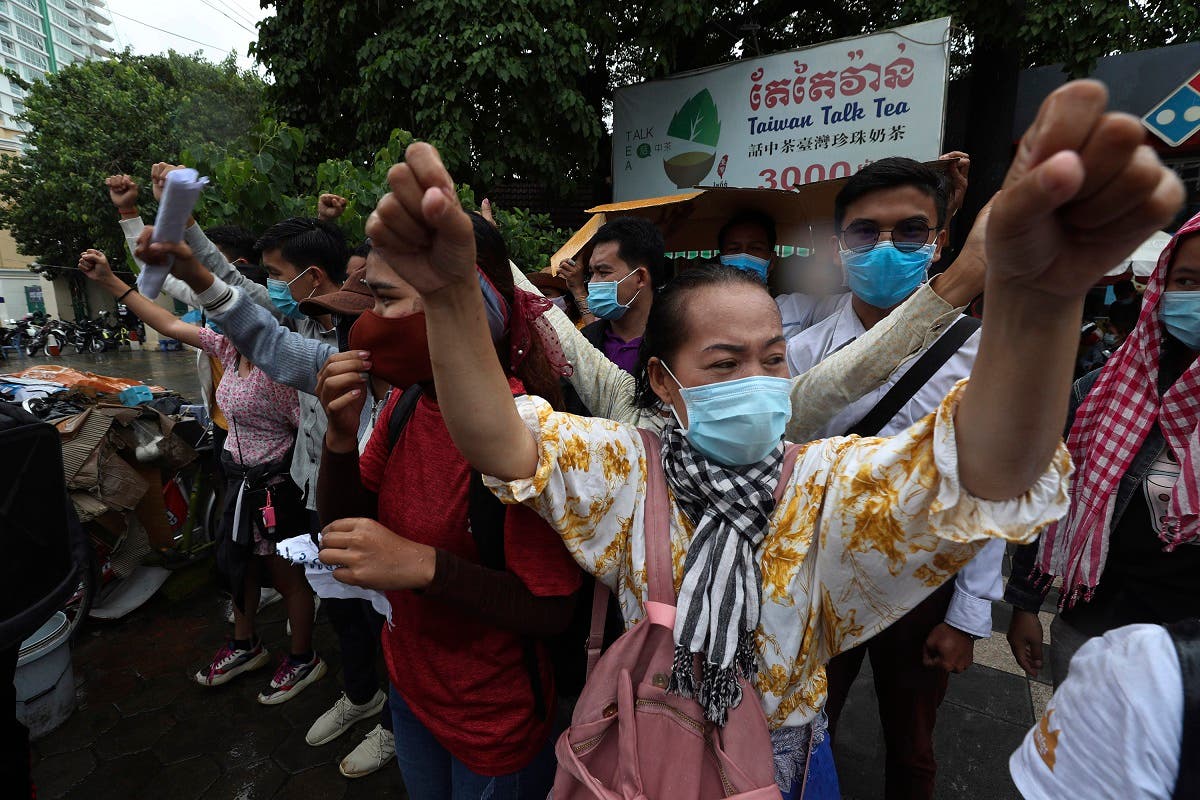 Supporters of Rong Chhun, president of the Cambodian Confederation of Unions, shout slogans in front of Phnom Penh Municipal Court in Phnom Penh, Cambodia, Saturday, Aug. 1, 2020. (AP)