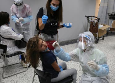 Health workers take swab samples from passengers who arrived at Beirut international airport, July 1, 2020. (Reuters)