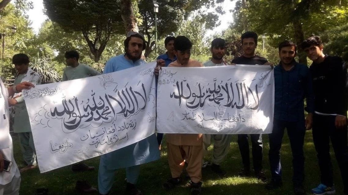 A Facebook post shared by Aref Ahmadi, an Afghan immigrant in Tehran, showed a group of men dressed in Afghan clothing carrying two flags of the Taliban.
