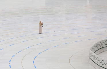 A mask-clad woman stands on a ring delineating where worshippers be around the Kaaba, Islam's holiest shrine, due to the COVID-19 coronavirus pandemic at the almost empty Grand Mosque in Saudi Arabia's holy city of Mecca. (AFP)