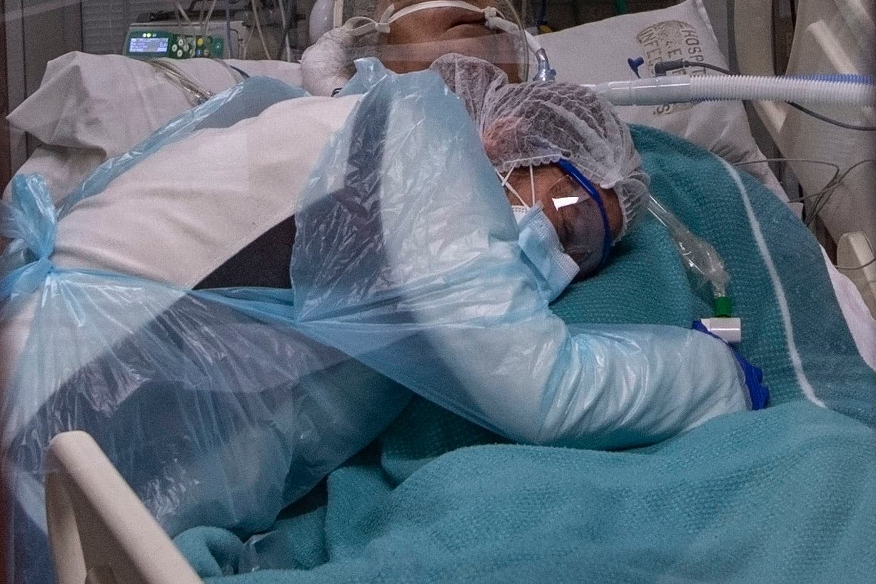 سيدة تحتضن مصاباً بكورونا في غرفة العناية الفائقة في أحد مستشفيات تشيلي