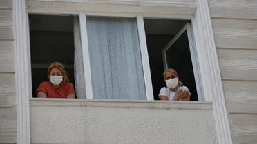 Betul Sahbas, 47, right, who had been experiencing COVID-19 symptoms, looks from her window in Istanbul on May 15, 2020. (AP)