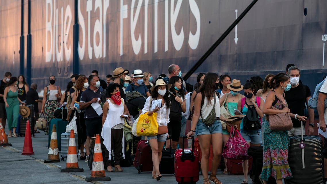 Passengers wait to board a ship bound to Greek Saronic islands at the port of Piraeus, near Athens, on Saturday, Aug. 1, 2020. Greek authorities introduced tougher restrictions this week following an increase in infections, most unrelated to tourism. (AP Photo/Yorgos Karahalis)