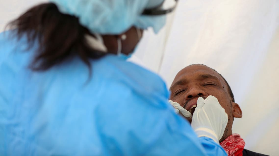FILE PHOTO: A medical worker wearing personal protective equipment (PPE) takes a swab sample from a man, as South Africa starts to relax some aspects of a stringent nationwide coronavirus disease (COVID-19) lockdown in Diepsloot near Johannesburg, South Africa, May 8, 2020. REUTERS/Siphiwe Sibeko/File Photo