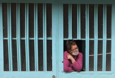 A woman looks out her home's window amid a lockdown to help curb the spread of the new coronavirus in Bogota, Colombia on June 12, 2020. (AP)
