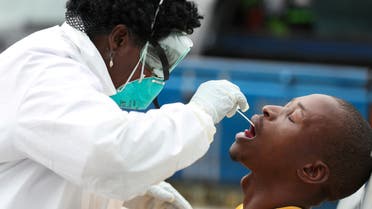 FILE PHOTO: A member of medical staff swabs the mouth of a resident as she is testing him for a virus, during a nationwide lockdown for 21 days to try to contain the coronavirus disease (COVID-19) outbreak, in Alexandra, South Africa, March 31, 2020. Picture taken March 31. 2020. REUTERS/Siphiwe Sibeko/File Photo