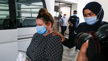 British national Samantha Jones, accused of killing her husband in 2018, is escorted by a police officer to a van after appearing in court in Alor Setar, in northern Malaysia, on August 3, 2020. (AFP)