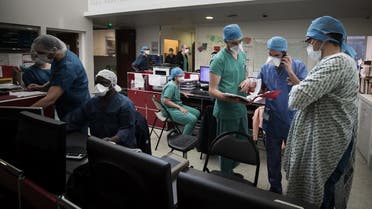 Medical workers look at coronavirus patients files at the intensive care unit of the Lariboisiere Hospital of the AP-HP (Assistance Publique - Hopitaux de Paris) in Paris on April 27, 2020. (AFP)
