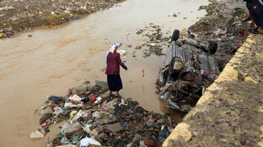 Yemenis check out a destroyed car under an overpass after it was overtaken by floods following heavy rains in the capital Sanaa, on April 14, 2020. (AFP)