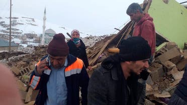 People stand on the debris of their collapsed house after an earthquake hit villages in Baskale town in Van province, Turkey, at the border with Iran. (File photo: AP)