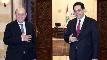 A handout picture provided by the Lebanese photo agency Dalati and Nohra on July 23, 2020 shows French FM Jean-Yves Le Drian and Lebanon’s PM Hassan Diab (R) at the governmental palace in Beirut. (AFP)