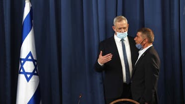 Israeli Defence Minister and Alternate Prime Minister Benny Gantz, wearing a protective face mask, speaks with speaks to Foreign Minister Gabi Ashkenazi during the weekly cabinet meeting in Jerusalem on May 31, 2020. (AFP)