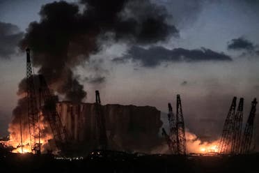 This picture taken on August 4, 2020 shows fires burning at the port of Lebanon's capital Beirut with its cranes in the aftermath of a massive explosion. (AFP)