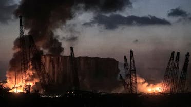 This picture taken on August 4, 2020 shows fires burning at the port of Lebanon's capital Beirut with its cranes in the aftermath of a massive explosion. (AFP)