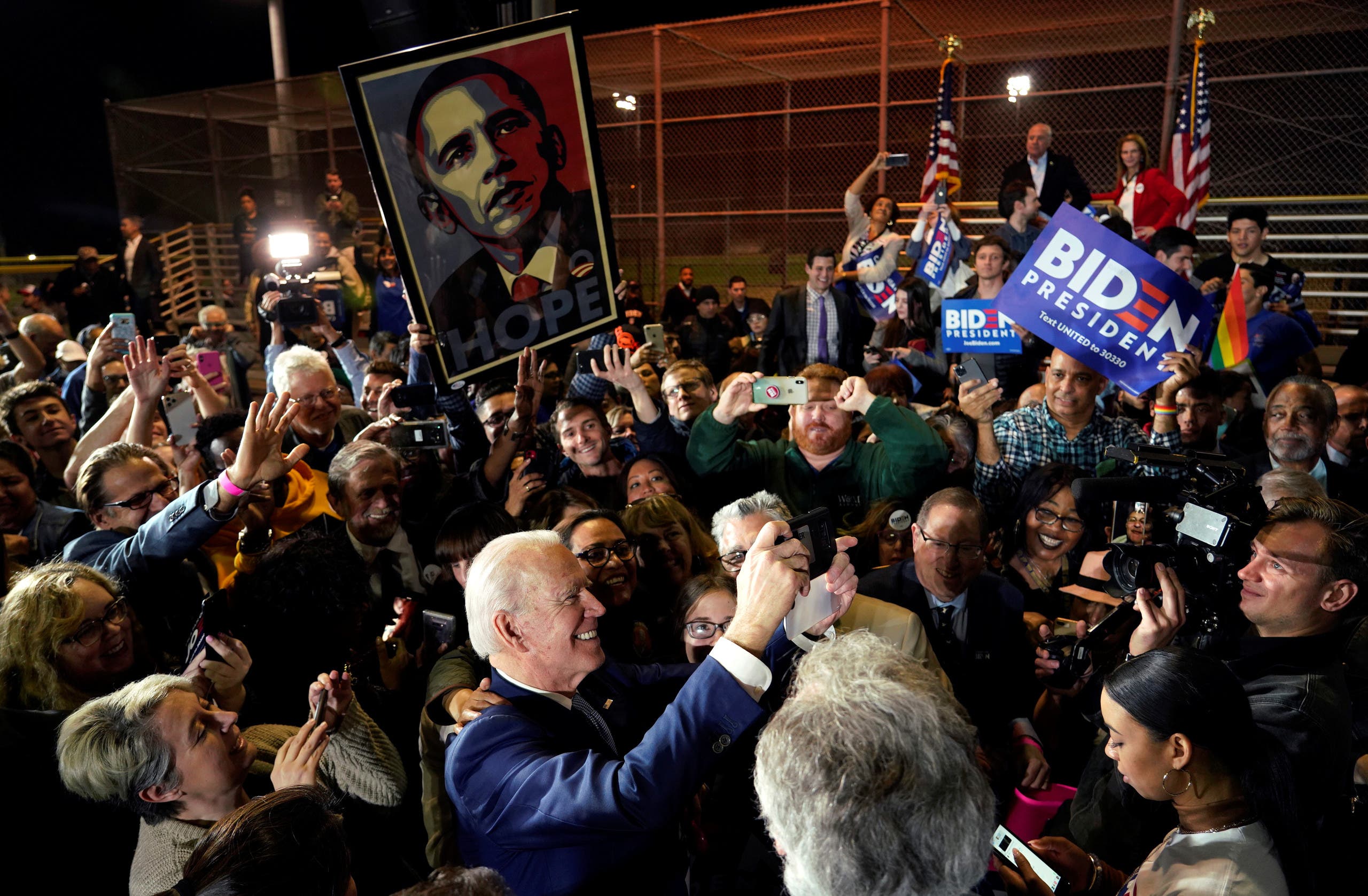 بادين خلال تجمع انتخابي في مارس الماضي ومؤيدوه يحملون صوراً لأوباما