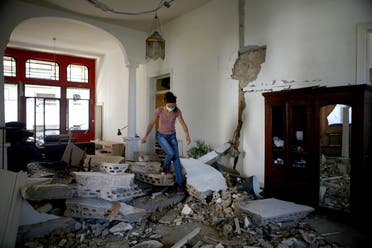 A Lebanese woman walks over the rubble in her apartment in the neighborhood of Gemmayze on August 5, 2020, a day after a blast in Beirut killed more than 100 people and wounded over 5,000. (AFP)