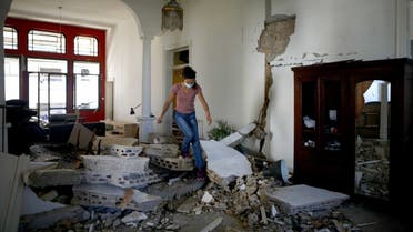 A Lebanese woman walks over the rubble in her apartment in the neighborhood of Gemmayze on August 5, 2020, a day after a blast in Beirut killed more than 100 people and wounded over 5,000. (AFP)