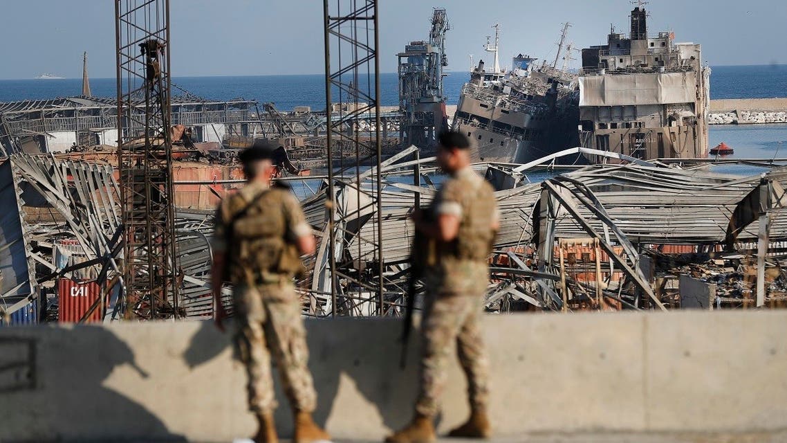 Lebanese army soldiers stand guard in front of destroyed ships at the scene where an explosion hit on Tuesday the seaport of Beirut, Lebanon. (AP)