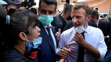 French President Emmanuel Macron, right, speaks with a woman as he visits the Gemmayze neighborhood, which suffered extensive damage from an explosion, Aug. 6, 2020. (AP)