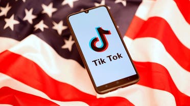 TikTok logo is displayed on the smartphone while standing on the US flag in this illustration picture. (Reuters)