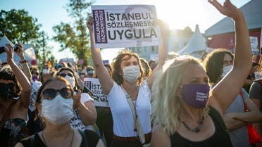 Demonstrators wearing protective face masks hold up placards during a demonstration for a better implementation of the Istanbul Convention to prevent and combat violence against women, in Istanbul, Turkey, on August 5, 2020. (AFP)