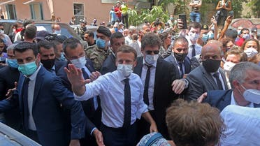 French President Emmanuel Macron greets people as he visits the Gemmayzeh neighborhood. (AFP)