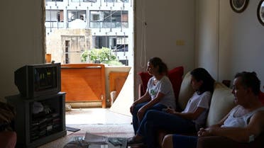 Youssef Afif and his family watch the television in their home that was damaged during Tuesday's blast in Beirut's port area, Lebanon August 7, 2020. REUTERS