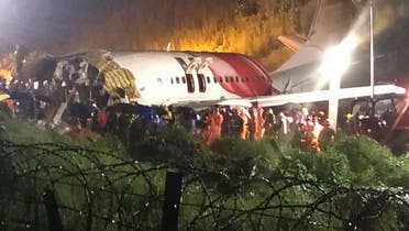 First responders gather around the wreckage of an Air India Express jet, which was carrying more than 190 passengers and crew from Dubai, after it crashed by overshooting the runway at Calicut International Airport in Karipur, Kerala, India, on August 7, 2020.  (AFP)