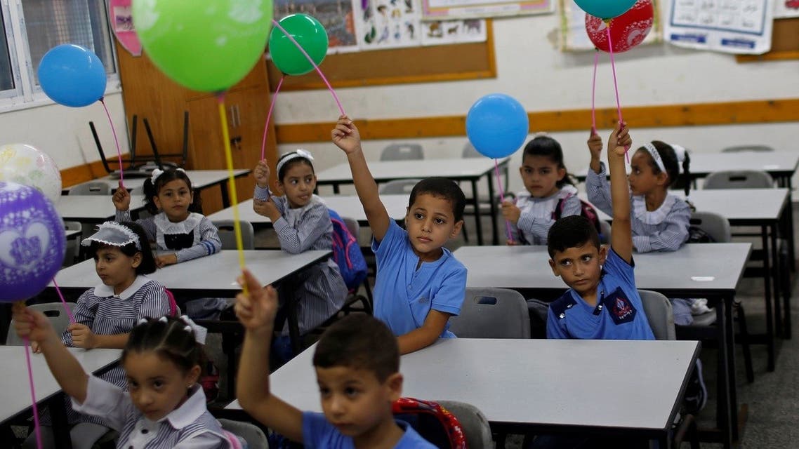 2020-08-0Palestinian students holding balloons sit in a classroom at a United Nations-run school as a new school year begins amid concerns about the spread of the coronavirus disease (COVID-19), in Gaza City, on August 8, 2020. (Reuters)8T080756Z_1227538425_RC2K9I95BBL9_RTRMADP_3_HEALTH-CORONAVIRUS-PALESTINIANS-SCHOOLS