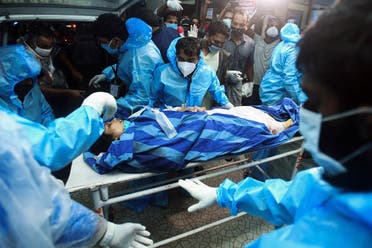 Health workers transfer an injured passenger on a stretcher to take her inside a hospital in Kozhikode, Kerala, after an Air India Express jet crashed by overshooting the runway at Calicut International Airport, on August 7, 2020. (AFP)