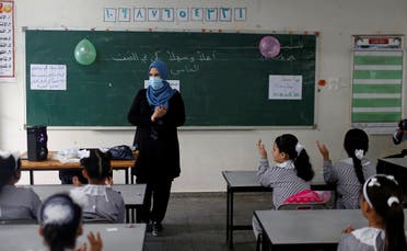 ce mask gestures as Palestinian students sit in a classroom at a United-Nations run school as a new school year begins amid concerns about the spread of the coronavirus disease (COVID-19), in Gaza City August 8, 2020. (Reuters)