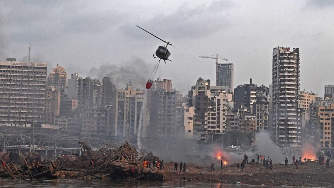 A helicopter try to put out multiple fires at the scene of the massive explosion that hit Beirut's port on August 4, 2020 in the heart of the Lebanese capital. (AFP)