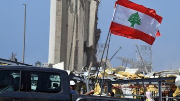 Lebanese people carry the national flag as they drive past the blast site in the capital Beirut on August 8, 2020. (AFP)