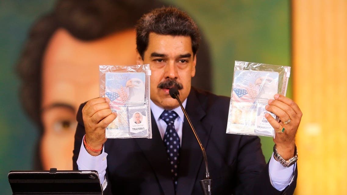 In this photo released by Venezuela's Miraflores presidential press office, President Maduro shows what authorities claim are identification documents of former U.S. special forces and U.S. citizens Airan Berry, right, and Luke Denman, left, during a online press conference in Caracas, Venezuela, Wednesday, May 6, 2020. (AP)
