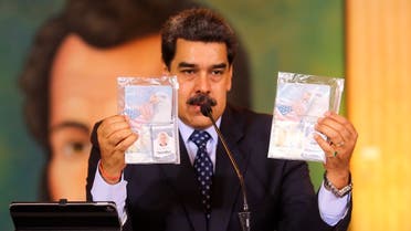 In this photo released by Venezuela's Miraflores presidential press office, President Maduro shows what authorities claim are identification documents of former U.S. special forces and U.S. citizens Airan Berry, right, and Luke Denman, left, during a online press conference in Caracas, Venezuela, Wednesday, May 6, 2020. (AP)