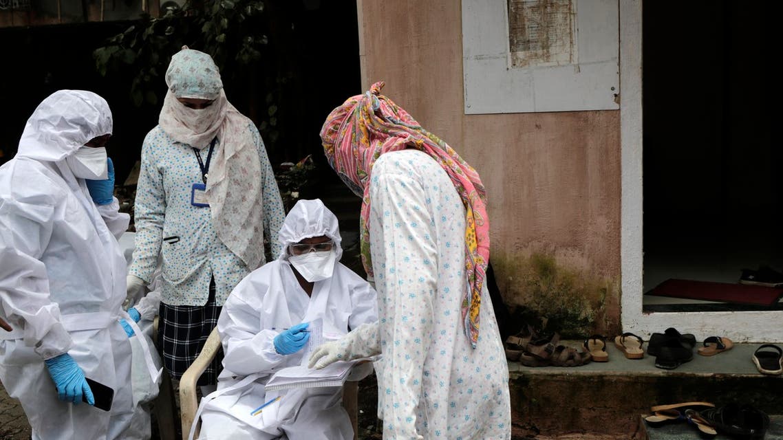 A health worker waits to take nasal swab samples to test for COVID-19 at a medical camp in Mumbai. (AP)