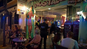 AP_2022Police officers talk with the owner of a bar as people sit at the terrace in Fuengirola, near Malaga, Spain, on August 8, 2020. (AP)1518025882